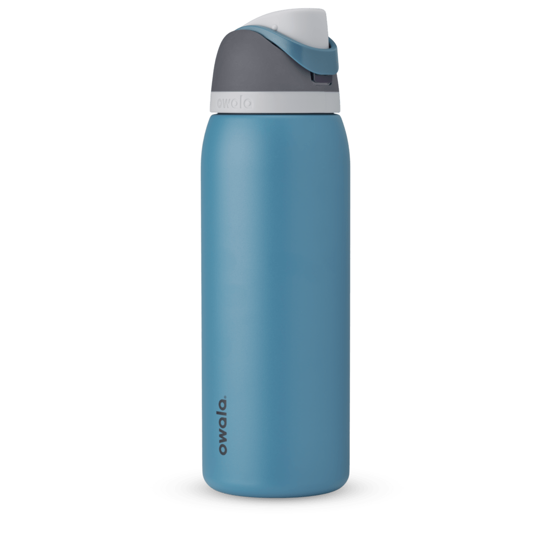 FreeSip 40oz in Blue Oasis, denim blue body with matching blue carry loop, dark gray flip cap, and white accent band